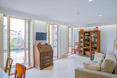 a living room with a couch and a tv at Casa Matriz Séc XVI in Penafiel
