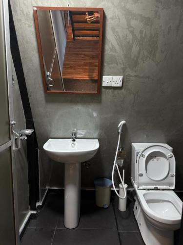 a bathroom with a sink and a toilet and a mirror at A frame Riverston in Matale