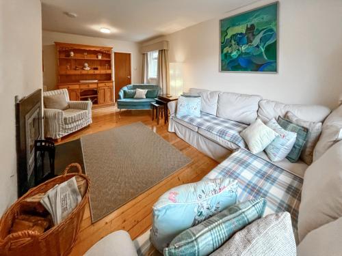 a living room with couches and a piano at Garden View Cottage - Uk50886 in Cupar