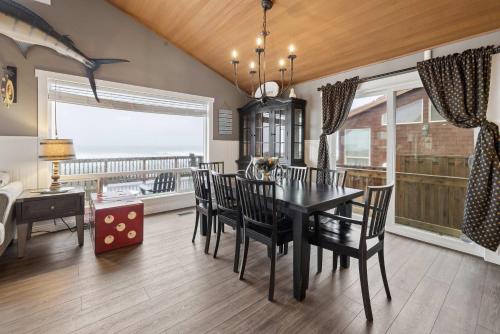 a dining room with a table and chairs and a balcony at Neptune's Watch in Gleneden Beach