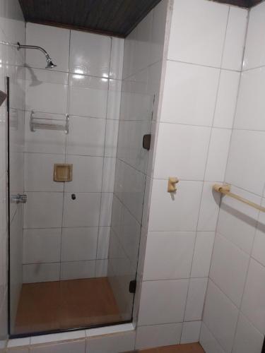 a shower with a glass door in a bathroom at Chalé Refúgio na Alameda Maringá MG in Bocaina de Minas