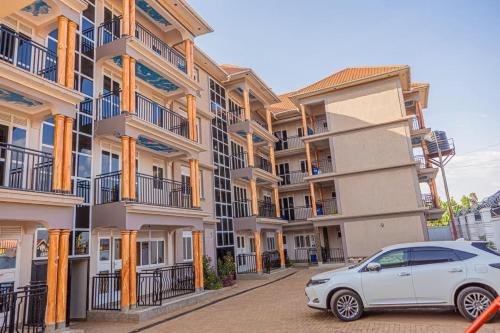 a white car parked in front of a building at Alma Hotels Kampala in Kampala