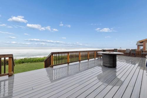 a deck with a table and a view of the ocean at Neptune's Watch in Gleneden Beach