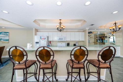 a kitchen with four chairs and a counter at Phoenix on the Bay 1303 condo in Orange Beach