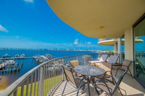 a balcony with a table and chairs and a marina at Phoenix on the Bay 1303 condo in Orange Beach