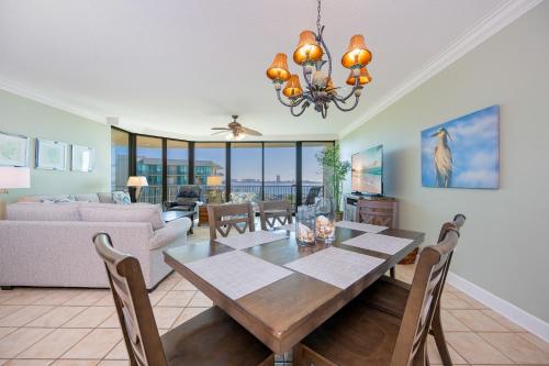a dining room and living room with a table and chairs at Phoenix on the Bay 1405 in Orange Beach