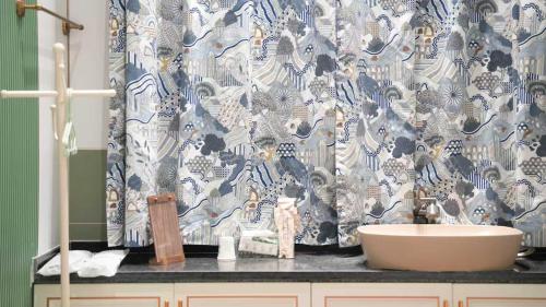 a bathroom with a sink and a shower curtain at Bao Di East Coast in Honghai