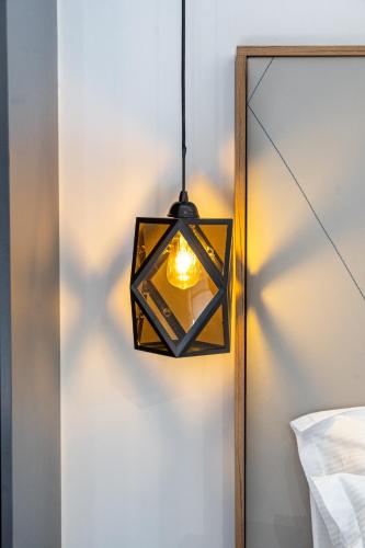 a lamp hanging from a wall next to a mirror at The Hill Aparthotel in Mostar
