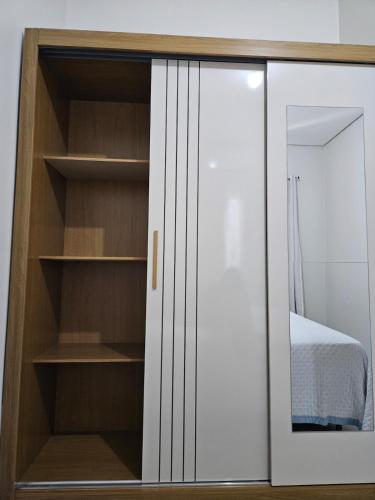 a bedroom with a white closet with shelves at Apartamento completo - a 3 minutos do centro in Alta Floresta