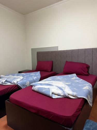two beds in a room with red and purple sheets at بورتو سخنه in Ain Sokhna