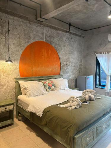 a bedroom with a large bed with an orange headboard at Tendan Residence in Legian
