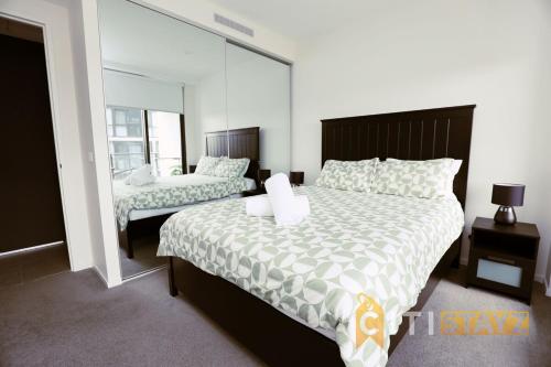 a bedroom with a large bed and a mirror at Lovely in Lyneham - 1bd 1bth Apt in Canberra