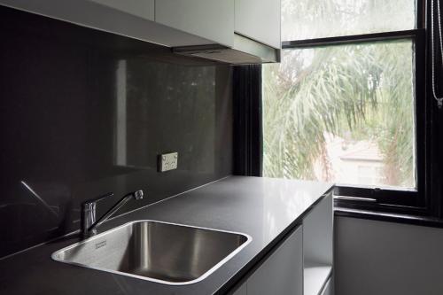 a kitchen counter with a sink and a window at Glebe Terraces in Sydney