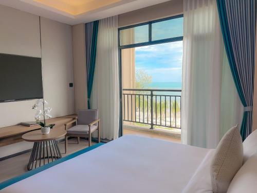 a hotel room with a bed and a view of the ocean at DongHu Resort Hotel in Sihanoukville