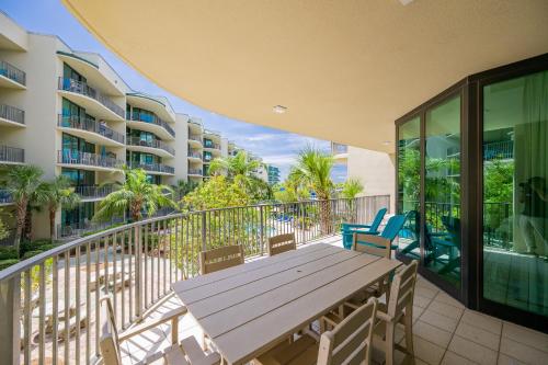 a deck with a wooden table and chairs on a balcony at Phoenix on the Bay 1217 in Orange Beach