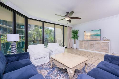 a living room with couches and a ceiling fan at Phoenix on the Bay 1217 in Orange Beach