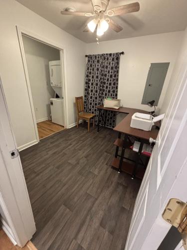 ein leeres Wohnzimmer mit Deckenventilator und Schreibtisch in der Unterkunft Craft Cottage in Berea