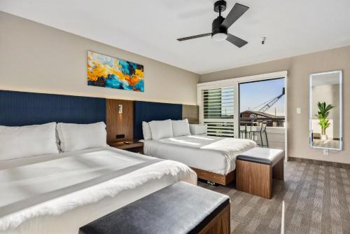a hotel room with two beds and a balcony at 456 Embarcadero Inn & Suites in Morro Bay