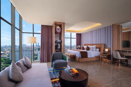 a hotel room with a bed and a living room at MORAZEN Surabaya in Surabaya