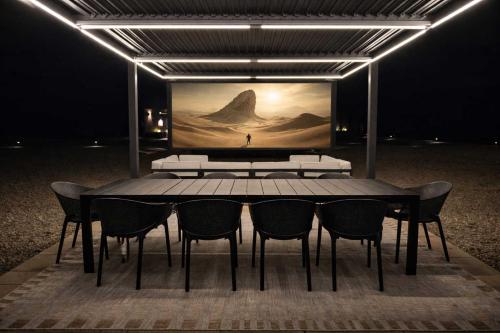 a dining room table with chairs and a painting on the wall at Luxury Glass Tiny House and Sauna in Torrey