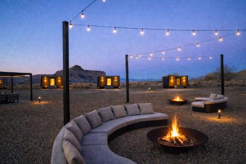 a fire pit in the middle of a desert with lights at Luxury Glass Tiny House and Sauna in Torrey