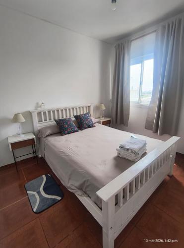 a white bed in a bedroom with a window at Vista sur in Buenos Aires