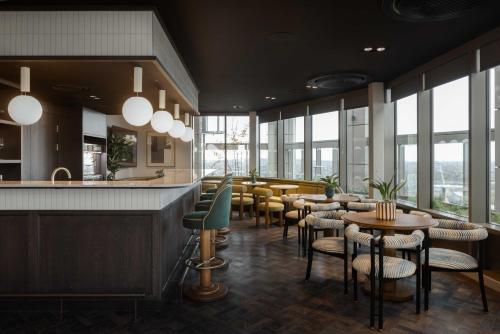 a restaurant with chairs and tables and windows at StayCozy Studio Apartments in Acton in London