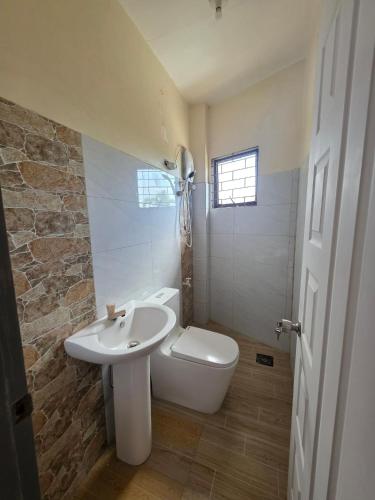 a bathroom with a white toilet and a sink at Rweydz Guest Inn in Tagbilaran City