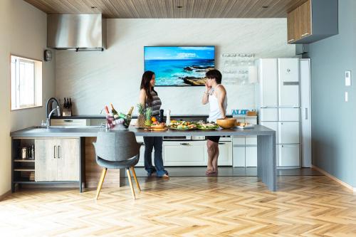 a man and a woman standing in a kitchen at RIPSTICK Private Luxury Resort in Otsu