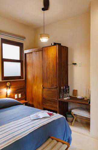 a bedroom with a bed and a wooden cabinet at Villas Indigo Troncones in Troncones