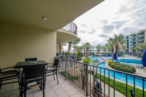 a balcony with a table and chairs and a view of a pool at Phoenix on the Bay 1129 condo in Orange Beach