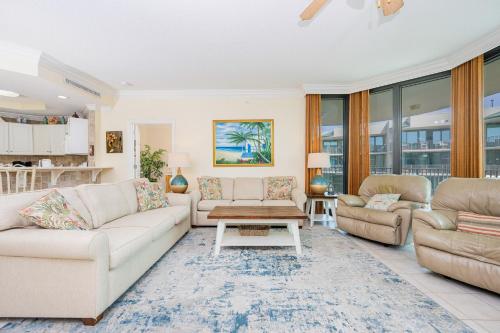 a living room with couches and a table at Phoenix on the Bay 1415 in Orange Beach