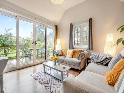 a living room with a couch and a table at Wisteria Cottage in Heathfield