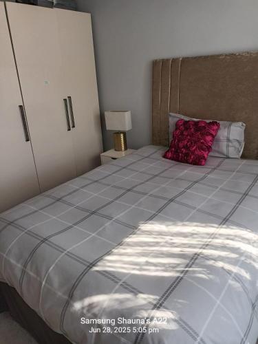 a bedroom with a large bed with a red pillow at Shauna's house in Poole