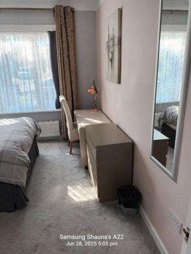 a bedroom with a bed and a desk and a mirror at Shauna's house in Poole