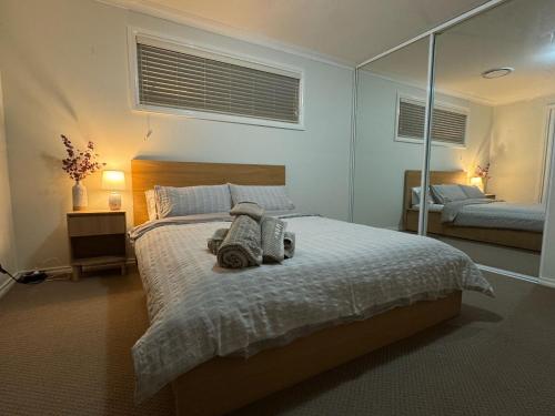 a bedroom with a large bed with a mirror at Beach Haven in Bunbury