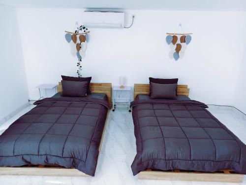 two beds sitting next to each other in a room at Joy Pool House in Kuta