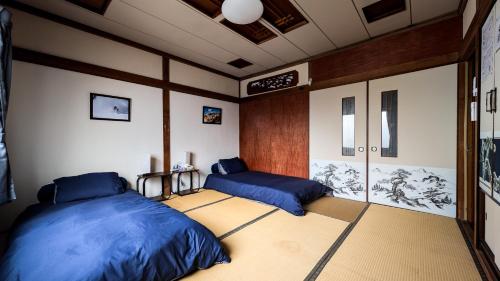 a room with two beds in a room at Tokachi Base Camp in Kami-furano
