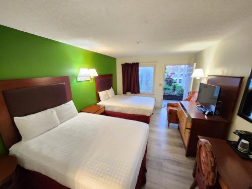 a hotel room with two beds and a television at Elk Inn Motel I-77,Exit 85 in Elkin