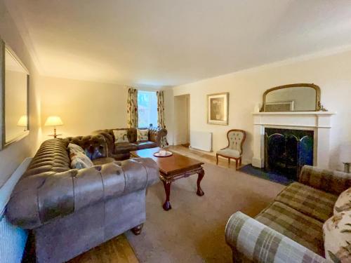 a living room with a couch and a fireplace at Grieves Cottage - Uk50908 in Cupar