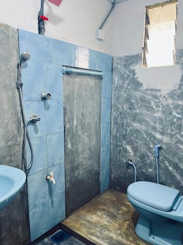 a bathroom with a blue toilet and a sink at Cinderella three arch view in Ella