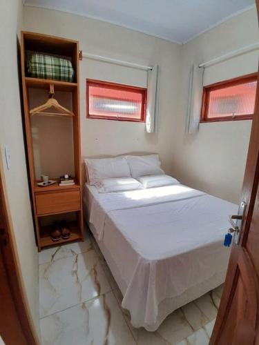 a bedroom with a white bed and a mirror at Chalé das águas in Cunha