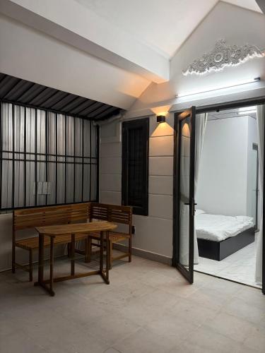 a room with a table and benches and a bed at Cốm Homestay in Hue