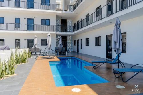 a pool in a building with chairs and umbrellas at Pool BBQ & a Short Walk to the Malecon in La Paz