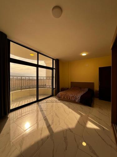 a bedroom with a bed and a large window at Rest Sea Chaliet & Farm in Edh Dhrā‘
