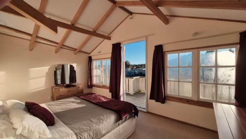 a bedroom with a bed and a large window at Kaha Lodge in Rangataua