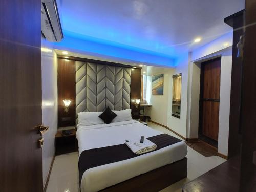 a bedroom with a large bed with a blue ceiling at Hotel Rio in Mumbai