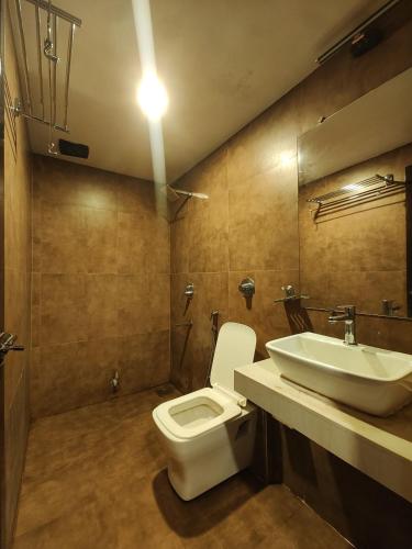 a bathroom with a toilet and a sink at Hotel Rio in Mumbai