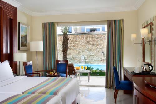 um quarto de hotel com uma cama e vista para uma piscina em Xperience Sea Breeze Resort em Sharm El Sheikk