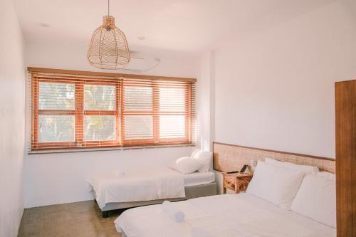 a room with two beds and a couch and a window at Villa Ramira in General Luna